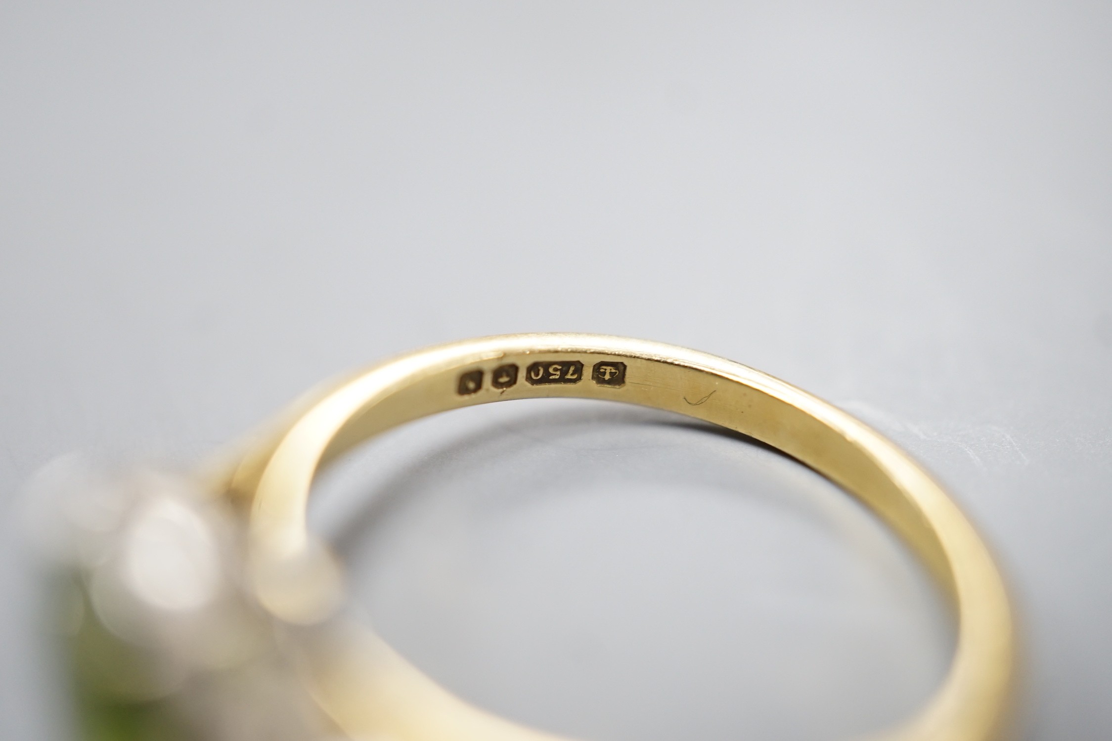 A modern 18ct gold and oval cut peridot ring, with diamond set shoulders, size M, gross weight 3 grams.